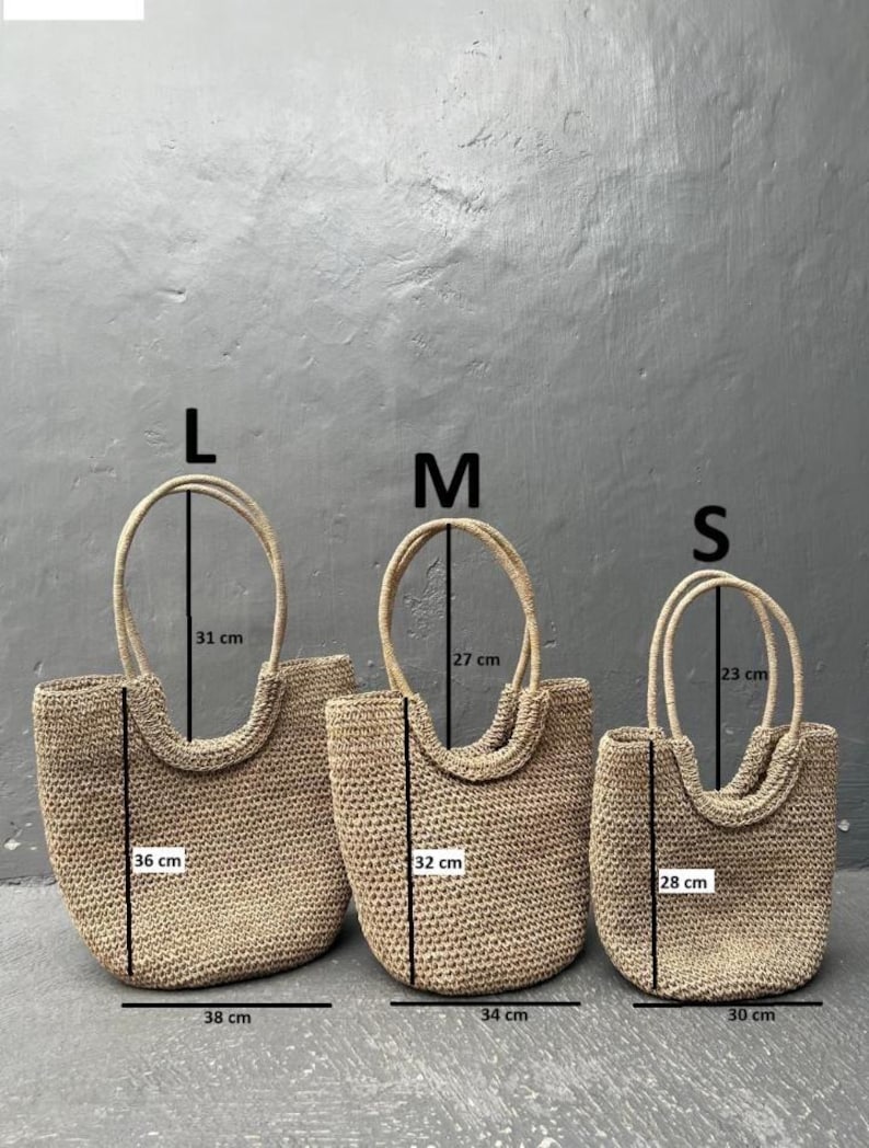 Pu&ograve; includere: Tre borse a mano in paglia di diverse dimensioni, etichettate L, M ed S. Le borse sono beige e hanno una trama intrecciata. Le misure di ogni borsa sono indicate in centimetri.