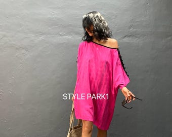 May include: A woman wearing a pink off-the-shoulder dress with black detailing on the sleeves. She is carrying a woven tote bag and holding sunglasses. The text "STYLE PARK1" is visible in the image.