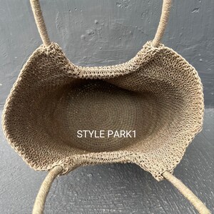Pu&ograve; includere: Una borsa tote in crochet beige con due manici. La borsa &egrave; vuota e l'interno &egrave; visibile. Il testo "STYLE PARK1" &egrave; visibile all'interno della borsa.