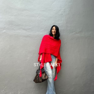May include: A woman wearing a bright red shawl, light blue flared jeans, and gold sandals. She is carrying a brown and black handbag. The text "STYLE PARK1" is visible on the image.