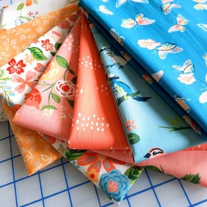 May include: A collection of eight fabric swatches featuring various floral and bird patterns. The fabrics are in shades of peach, orange, blue, and white.