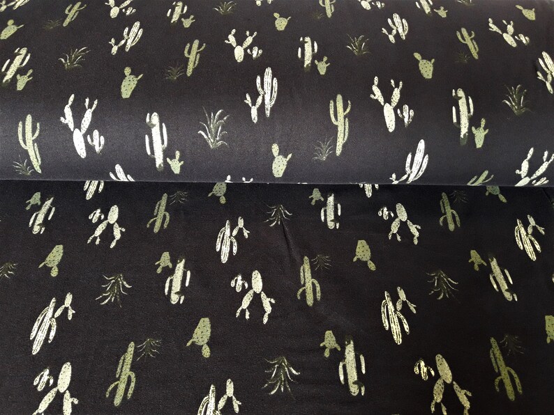 May include: Black fabric with a repeating pattern of green cactus plants. The fabric has a soft, textured feel.