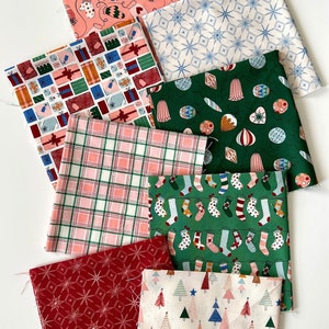 May include: A set of eight fabric squares with various Christmas-themed patterns. The patterns include presents, ornaments, snowflakes, stockings, plaid, and Christmas trees. The fabrics are in shades of red, green, pink, blue, and white.