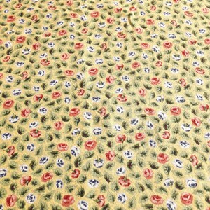 May include: Yellow fabric with a repeating pattern of small red and white flowers with green leaves.