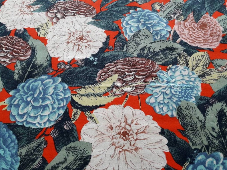 May include: Red fabric with a floral print featuring white, blue, and brown flowers. The flowers are stylized and have a vintage look.