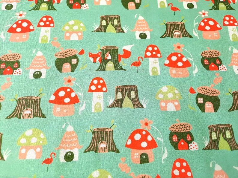 May include: A teal fabric with a repeating pattern of mushroom houses, tree stumps, foxes, and flamingos. The houses are red, green, and white with white polka dots. The tree stumps are brown with green leaves. The foxes are orange with white tails. The flamingos are pink with black legs.