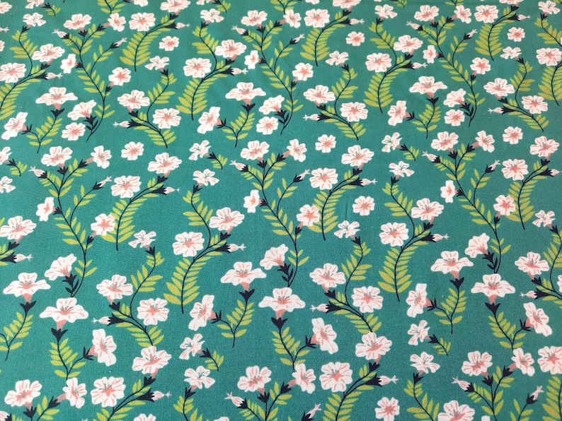 May include: Teal fabric with a white floral pattern. The flowers are small and have a pink center. The fabric has a subtle sheen.