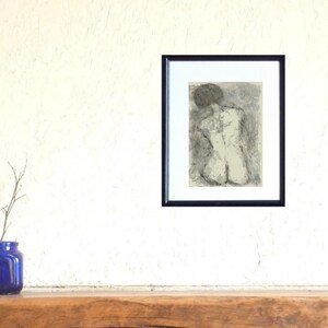 May include: A black and white drawing of a nude figure in a seated pose, framed in a black frame.
