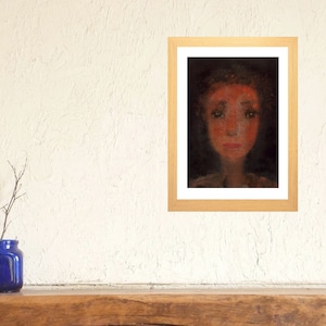 May include: A framed painting of a person's face. The person has a red face and is looking directly at the viewer. The background is dark.