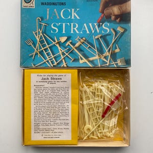 May include: Vintage Waddington's Jack Straws game box. The blue box features the game title and illustrations of the game pieces. The box is open, revealing the game pieces and instructions. A classic family game.