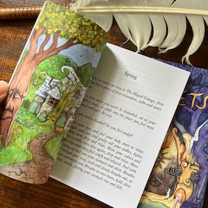 May include: An open book with colorful illustrations and text. The left page shows a whimsical cottage scene with a tree. The right page has the word "Spring" and relaxation instructions. A white feather rests nearby.