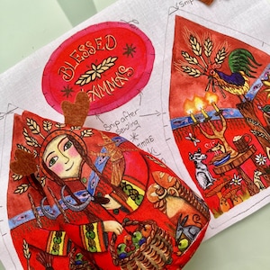 Puede incluir: Un diseño colorido de estilo arte popular que presenta a una mujer con un atuendo rojo sosteniendo una cesta de frutas. El diseño incluye el texto "BLESSED XMMS" en un óvalo rojo y un gallo. También hay dos pequeñas astas de fieltro marrón.