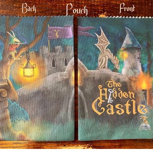 May include: A fabric pouch with a fantasy castle scene. The front features a dragon on a tower and the words "The Hidden Castle." The back shows a tree with a figure and a lantern. The pouch is in shades of blue, green, and brown.