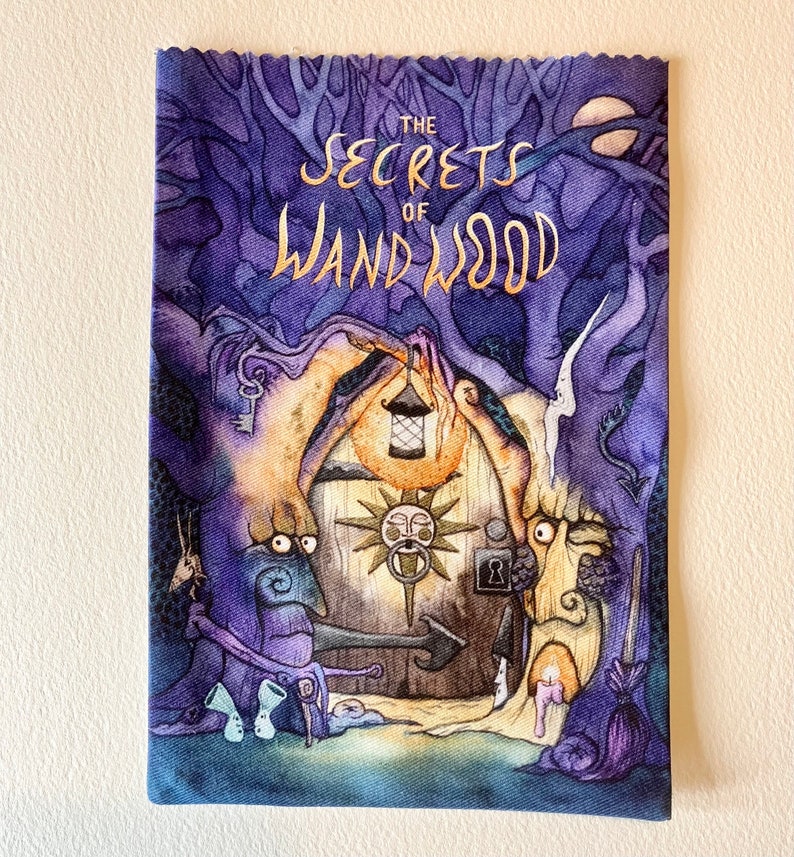 May include: A purple and blue illustrated book cover with the title "The Secrets of Wand Wood" in gold lettering. The cover features a whimsical illustration of a house with a door and a sun-like symbol above it.
