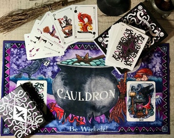 May include: A witch-themed tarot card set with a deck of cards, a box, and a play mat. The mat features a cauldron illustration with the word "CAULDRON" and the phrase "Be Wickede!". The cards have unique illustrations and the box says "THE 4 COVERS".