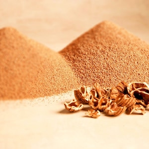 以下が含まれることがあります： 薄い茶色の粉末の山が2つ、おそらく砕いたナッツの殻で、手前に割れたクルミの殻がいくつかある。