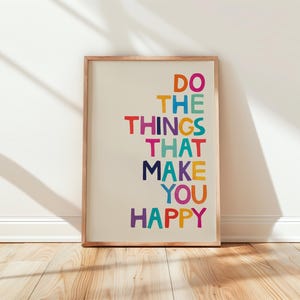 May include: A framed print with the text "Do the things that make you happy" in a colorful rainbow font.
