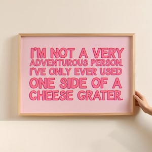 Peut inclure: Une impression encadrée rose avec le texte "I'M NOT A VERY ADVENTUROUS PERSON. I'VE ONLY EVER USED ONE SIDE OF A CHEESE GRATER."