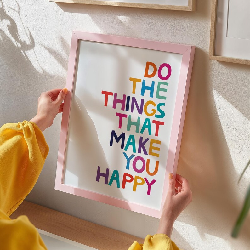 May include: A pink framed print with the text "Do the things that make you happy" in colorful letters.