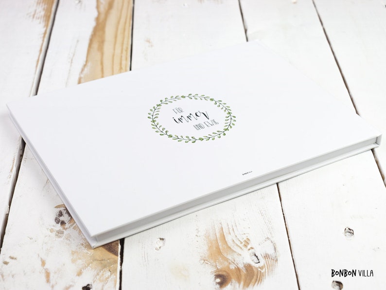 May include: White photo album with a green leafy wreath and the text "for immer and ever" in black.