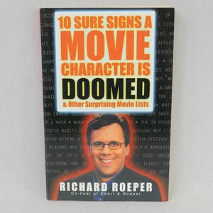 May include: A book titled "10 Sure Signs a Movie Character is Doomed" with the author Richard Roeper. The cover features a man in glasses and the book's title in large orange and black text.
