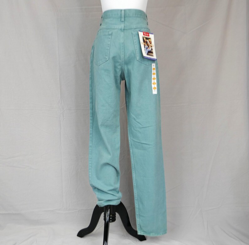 K&ouml;nnte beinhalten: Hellblau-t&uuml;rkisfarbene Jeanshose mit hoher Taille und geradem Bein. Die Hose hat ein klassisches F&uuml;nf-Taschen-Design und ein Etikett an der Ges&auml;&szlig;tasche. Die Hose wird auf einer Schaufensterpuppe pr&auml;sentiert.