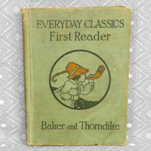May include: Vintage "Everyday Classics First Reader" book with a green cover. The cover features a circular illustration of a child playing a horn, with text reading "Everyday Classics First Reader" and "Baker and Thorndike".