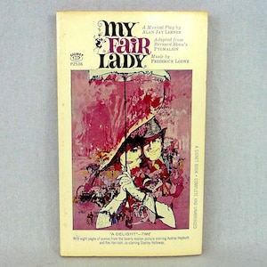 Peut inclure: Livre de poche vintage "My Fair Lady" avec une couverture rose et blanche représentant des personnages et un parapluie. Le livre est un Signet Book, complet et non abrégé.