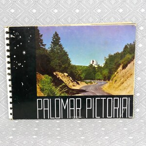 May include: A spiral-bound book titled "PALOMAR PICTORIAL" showing a road through a mountain landscape. The cover has a black border with white stars and a picture of a white observatory.