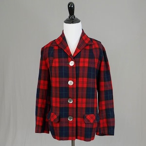 May include: A red, navy, and green tartan blazer with three white buttons and two front pockets. The jacket is displayed on a black mannequin. The tartan pattern is a classic design, suitable for various occasions.