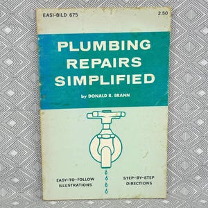 以下が含まれることがあります： ドナルド・R・ブラン著のヴィンテージの取扱説明書「Plumbing Repairs Simplified」。ティールとオフホワイトの表紙に、中央に水道の蛇口のイラスト、Easi-Bild 675、ステップバイステップの指示を示すテキストが記載されています。