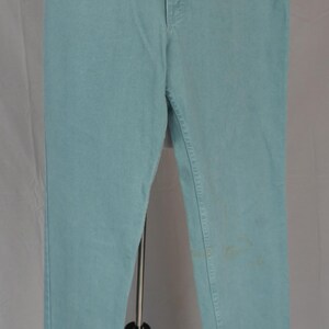 K&ouml;nnte beinhalten: Hellblaue Jeans mit klassischem F&uuml;nf-Taschen-Design. Die Jeans werden auf einer Schaufensterpuppe pr&auml;sentiert, die ihre gerade Beinpassform und den Knopfverschluss hervorhebt. Die Jeans haben ein verwaschenes Aussehen.