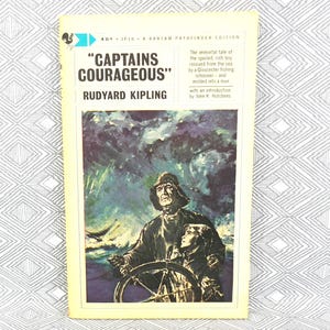 May include: A vintage paperback book cover featuring an illustration of a man and a boy on a ship's wheel in a stormy sea. The book title is "CAPTAINS COURAGEOUS" by Rudyard Kipling.