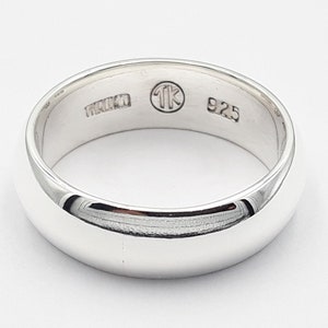 Pode incluir: Um anel de banda de prata com as marcas "1K" e "925" no interior.