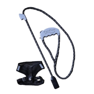 May include: A black and gray dog leash and harness set. The leash has a gray handle with the word "Bendless" printed on it. The harness is black with reflective strips and adjustable straps.