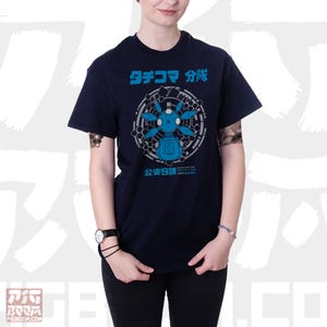 May include: A navy blue t-shirt with a graphic of a blue robot with the text "ダチコマ 分隊" and "公安9課" in Japanese.