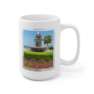 May include: White ceramic mug with a colorful image of the Pineapple Fountain in Charleston, South Carolina. The text "Charleston" and "South Carolina" are printed on the mug.
