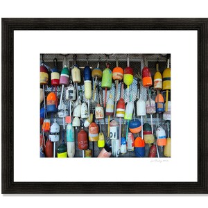 Puede incluir: Una pared con una colecci&oacute;n de boyas de madera coloridas y desgastadas con n&uacute;meros y letras pintadas. Las boyas est&aacute;n colgadas de una malla de alambre.