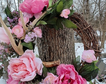Couronne de vigne printanière avec bois de cerf de Virginie naturels et accents floraux pour une décoration murale de cabine ou une porte d'entrée.