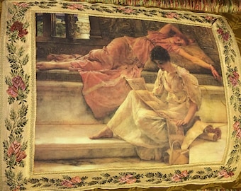 Puede incluir: Una almohada decorativa con fondo dorado y borde floral. La almohada presenta una pintura vintage de dos mujeres en una habitación con suelo de mármol. Una mujer está tumbada y la otra está sentada y leyendo un libro.