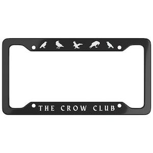 May include: Black metal license plate frame with a white silhouette of crows and the text "THE CROW CLUB".