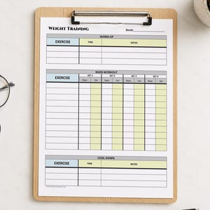 May include: A wooden clipboard holding a white weight training log sheet with sections for warm-up, main workout, and cool-down. The form includes columns for exercise, time, notes, reps, and lbs. Black-rimmed glasses and a black pen are present.