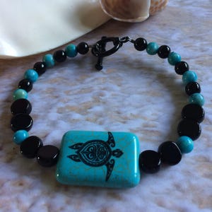 Sea turtle, beaded bracelet, in black and turquoise.