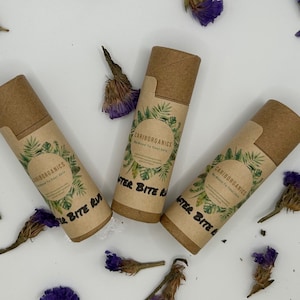 Puede incluir: Tres tubos de cartón marrón con etiquetas verdes y blancas. Las etiquetas tienen el texto "Cariborganics" y "After Bite Rub".