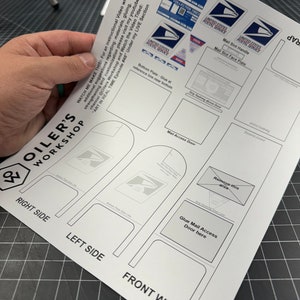 May include: A printable papercraft model of a United States Postal Service mailbox. The model includes instructions for assembly and a QR code for a video tutorial. The model includes a mail slot handle, mail slot face plate, and mail access door.