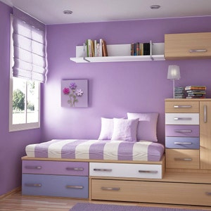 May include: A purple bedroom with a bed, drawers, and a bookshelf. The bed has a striped comforter and pillows. The drawers are in shades of purple, white, and wood. A window with a shade is on the left.