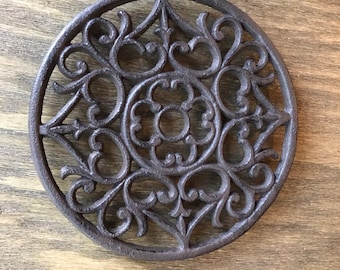 Round cast iron trivet and potholder with intricate and beautiful design made of cast iron