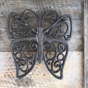 Peut inclure: Décoration murale en métal noir en forme de papillon avec un motif de volutes complexes.