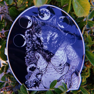 May include: Black and white sticker of a wolf with a full moon and crescent moons in the background. The wolf is howling and has a fierce expression. The sticker is on a green leafy background.