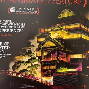 May include: Poster for an animated film featuring a detailed illustration of a traditional Japanese building with illuminated windows and a red bridge. The poster includes text and awards.